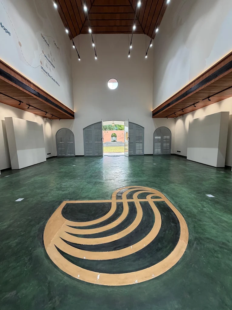 A high-ceilinged hall at One Kochi with a green terrazzo floor and arched doorways